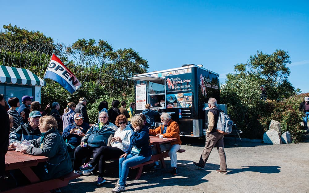 A photo of the Cousins Maine Lobster Portland, Maine location, crowded with guests at picnic tables, enjoying Cousins Maine Lobster food.