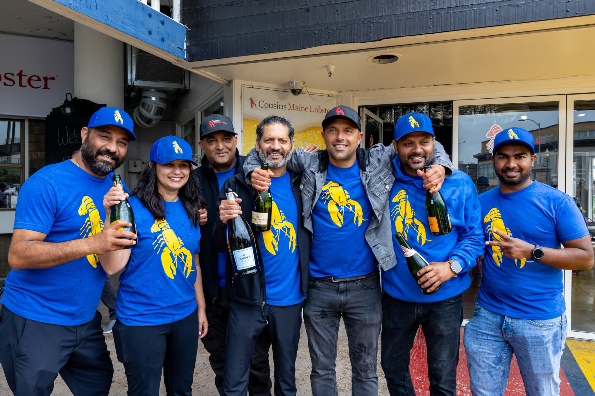 The Cousins Maine Lobster San Francisco Family poses with Cousin Sabin & Champagne bottles to celebrate the opening of the Pier 41 Restaurant.