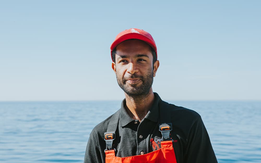 A photo of our Orange County owner standing in fishing gear with the ocean in the background.